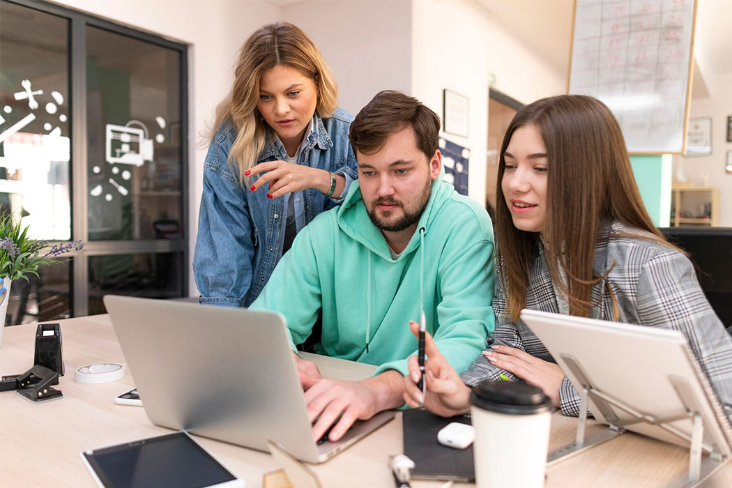 Echipă mică colaborând la un proiect digital